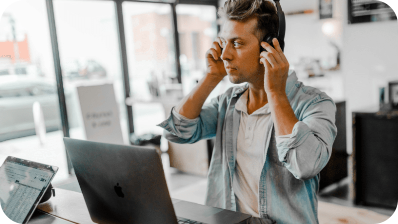Male professional with headphones in a modern office setting